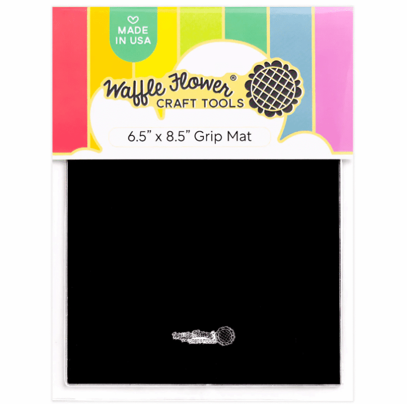 L'immagine è la foto di un prodotto dentro la sua confezione: si tratta di un rettangolo nero, con la marca Waffle Flower scritta in un'aletta di carta multicolore posizionata sul lato corto del rettangolo, in alto