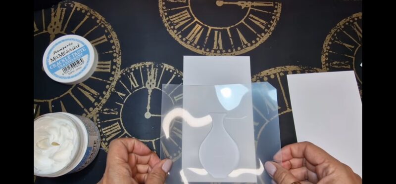 in questa immagine, sopra un foglio bianco è appoggiato un foglio di plastica trasparente in cui c'è la sagoma di un vaso