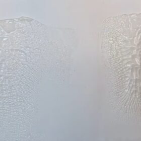 si vede un foglio bianco su cui ci sono due aree coperte da una pasta trasparente che fa un effetto raggrinzito e craklé