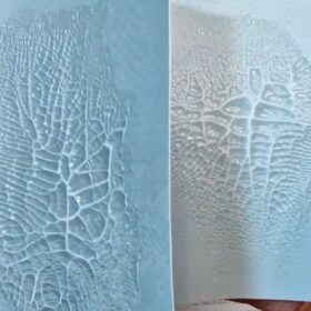 si vedono da vicino due rettangoli di carta, uno con lo sfondo azzurrato e uno bianco, entrambe con l'effetto raggrinzito